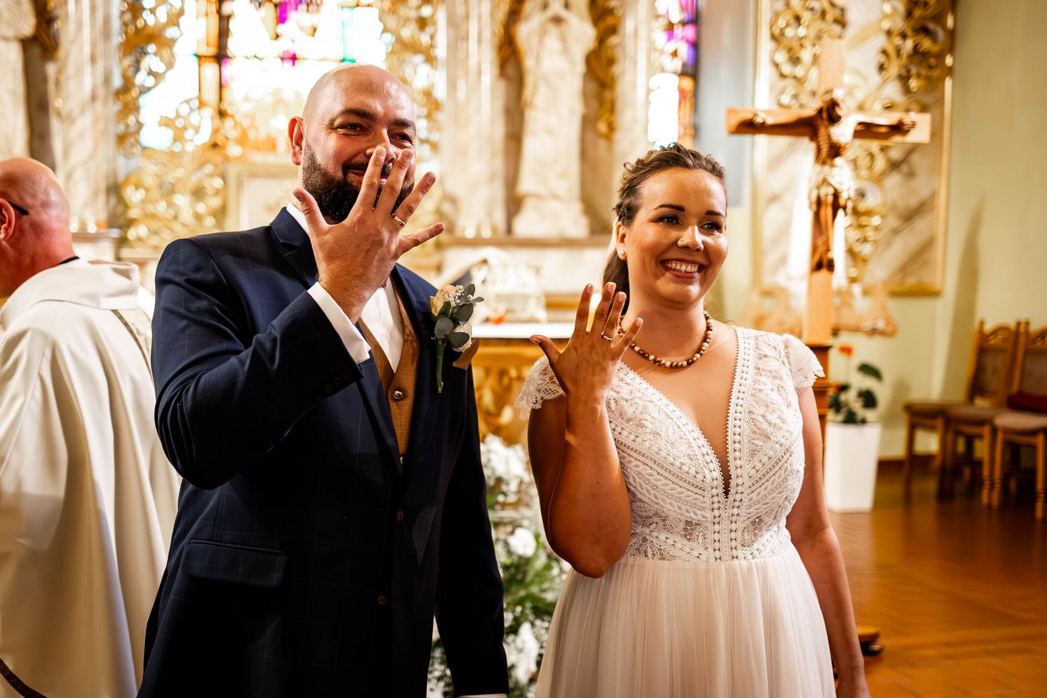 Joyful wedding celebration in an ornate gold-decorated venue.