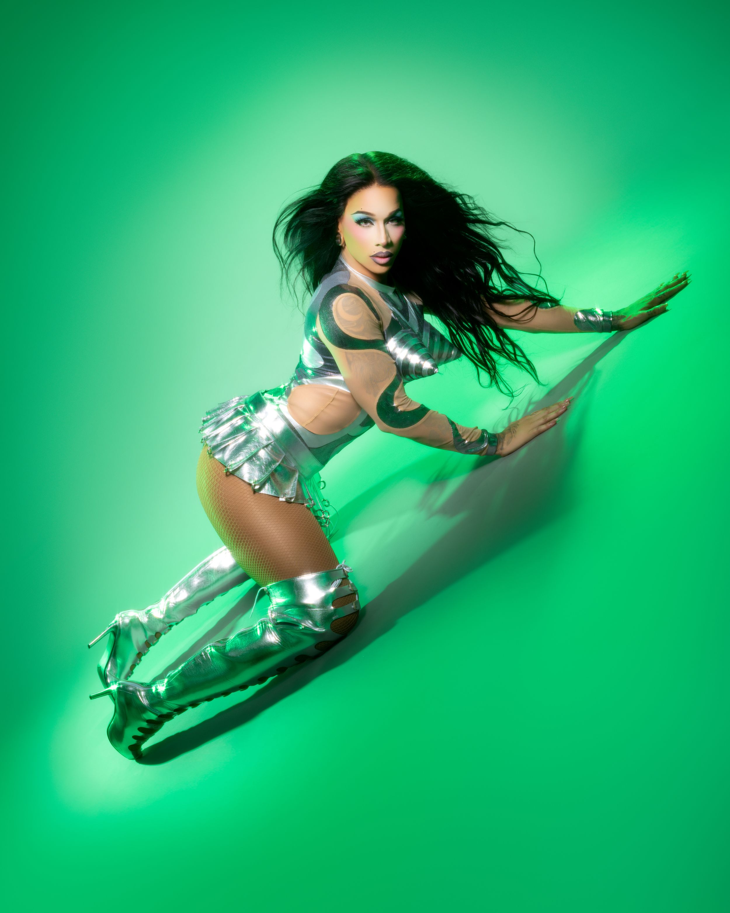Athletic figure in metallic outfit strikes dynamic poses against vibrant green backdrop in fashion photo sequence.