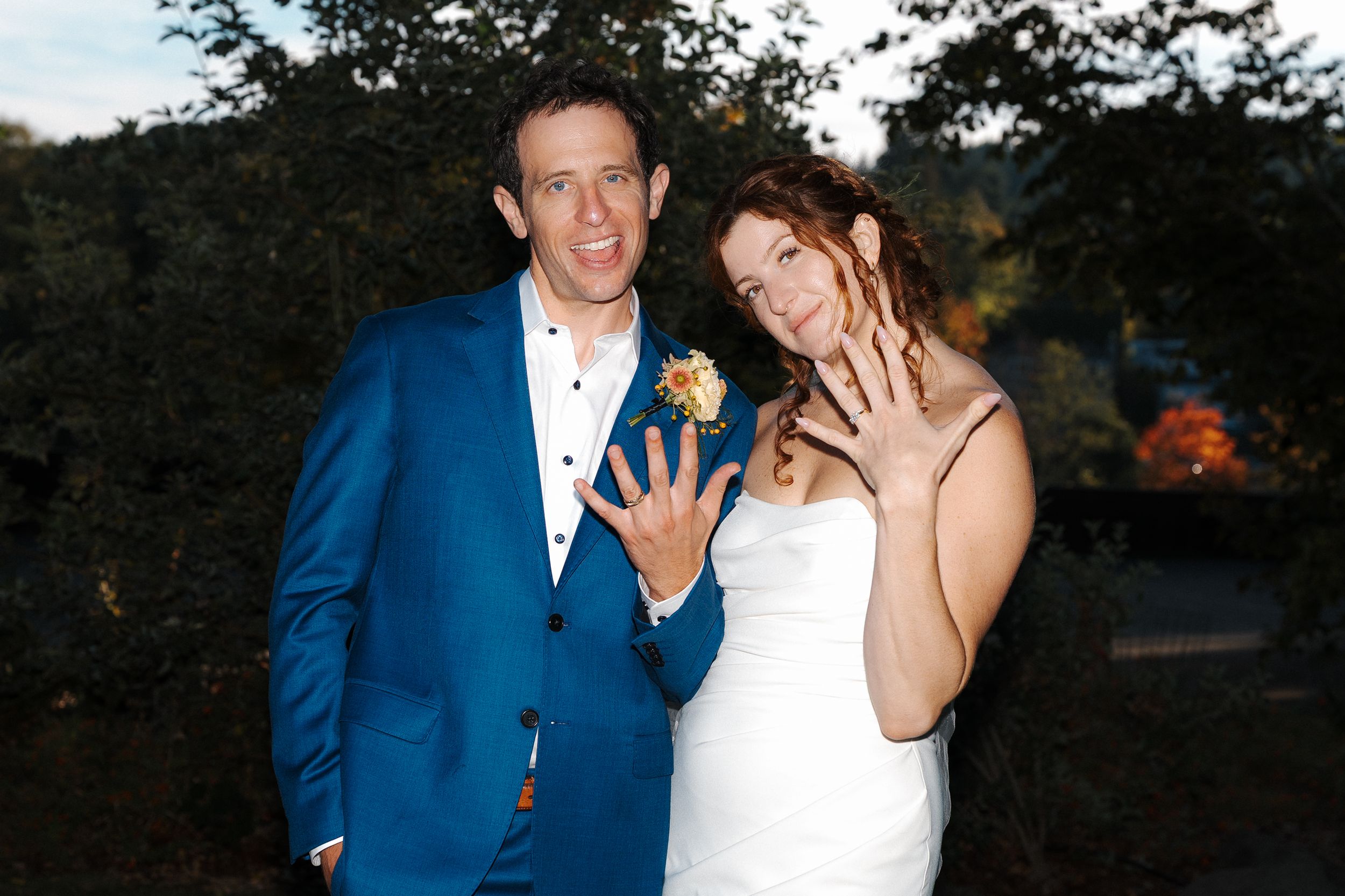 Newlyweds share a romantic moment at sunset in an outdoor garden setting.