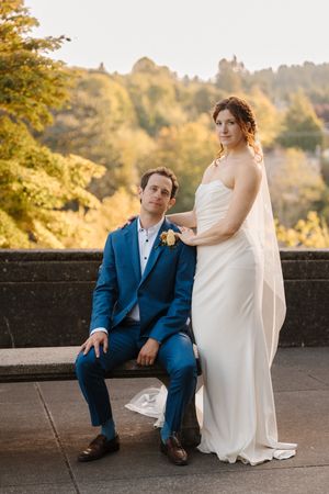A couple in wedding attire poses together at sunset on stone steps during their outdoor autumn photo session.