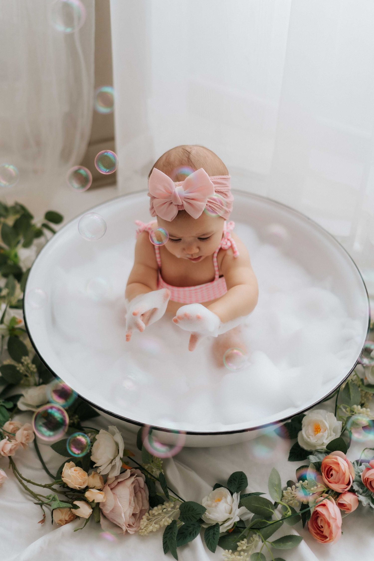 A small doll wearing a blue knit top and white sunglasses sits against a pastel background with festive bunting.