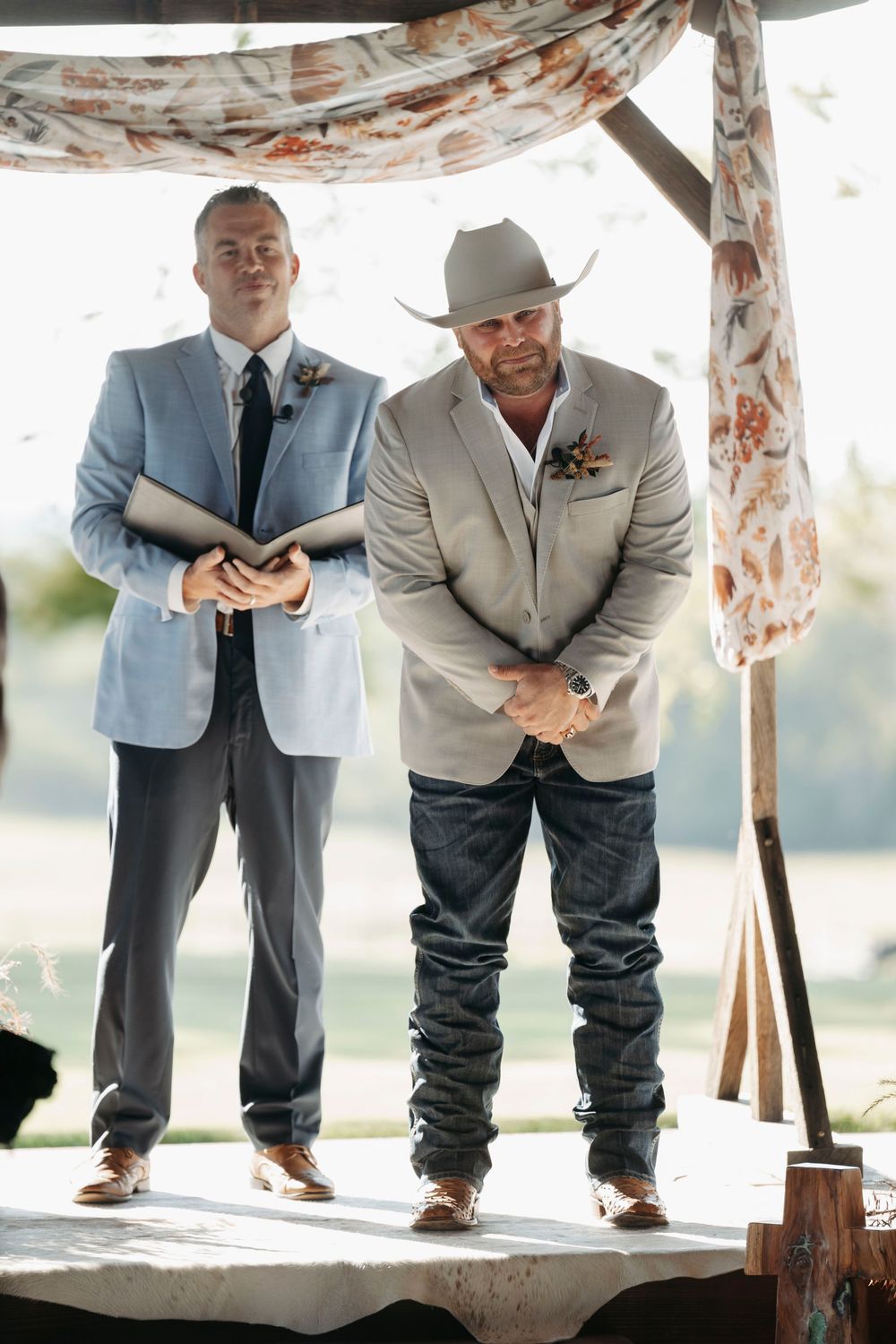 A fun wedding photo series showing groomsmen's legs and shoes lined up under a floral arch.