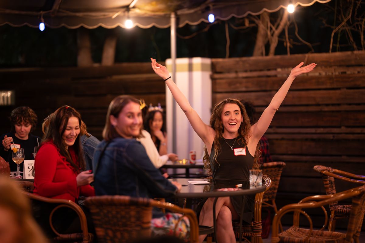 Diners enjoying a lively evening at a rustic restaurant with warm lighting and wooden interior decor.
