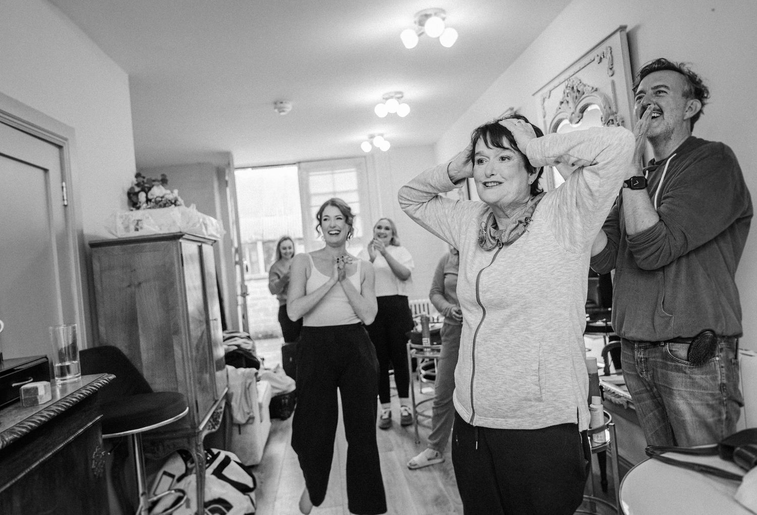A series of black and white candid photos showing people dancing and laughing together in an indoor setting.