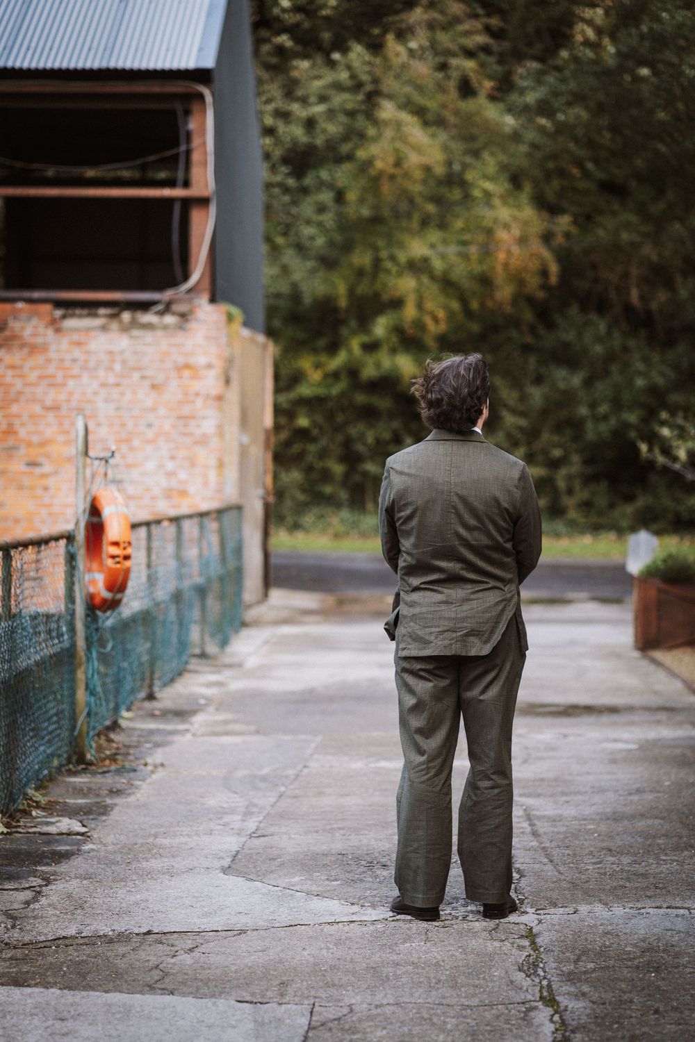 A sequence of photos showing a person in green attire walking away on a concrete path beside a brick wall.