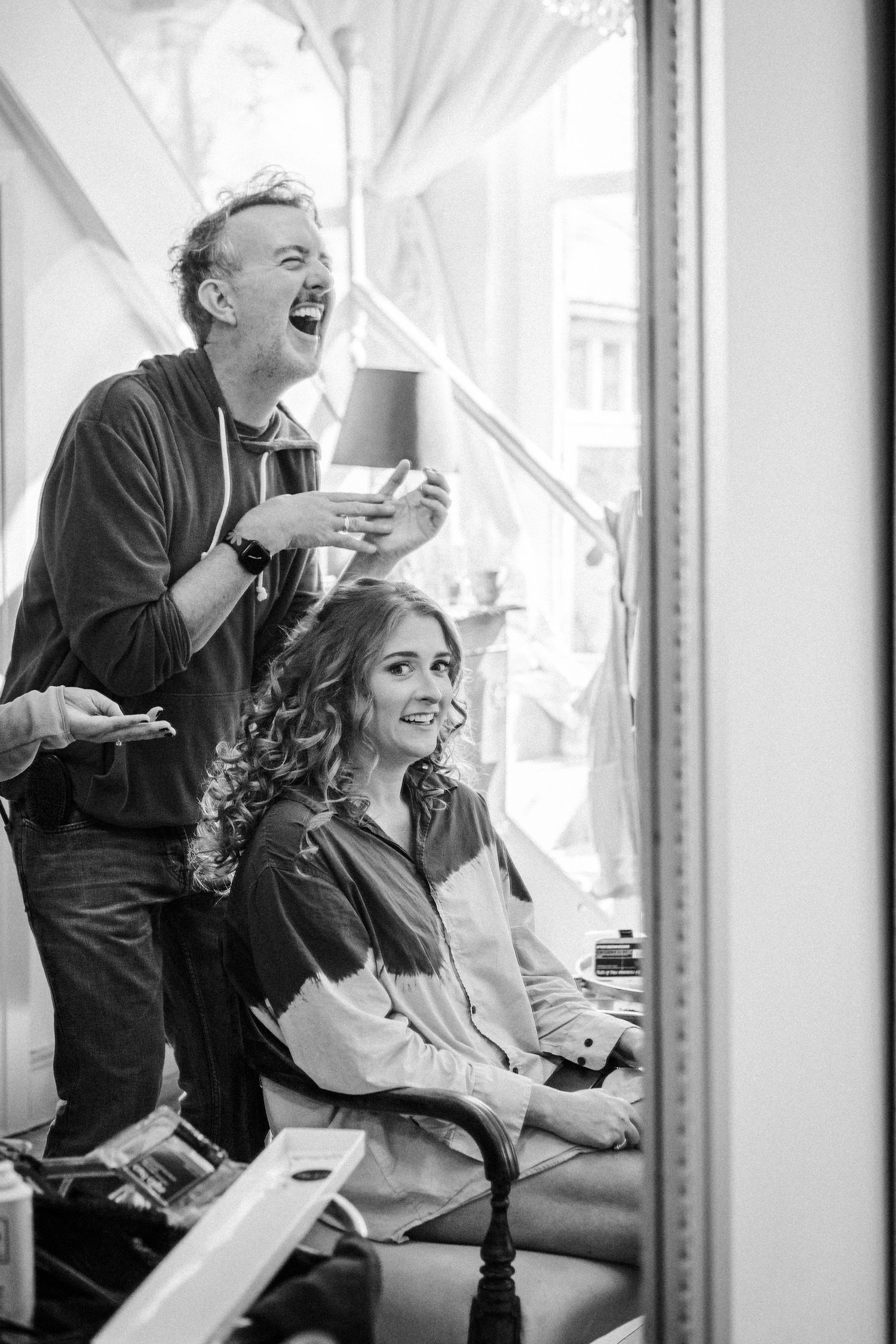 A series of black and white photos showing people laughing heartily in what appears to be a candid sequence.
