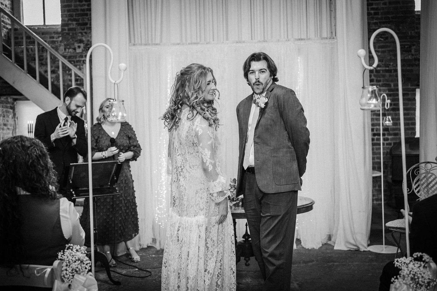 A collection of black and white wedding reception photos showing guests mingling and dancing at an elegant venue.