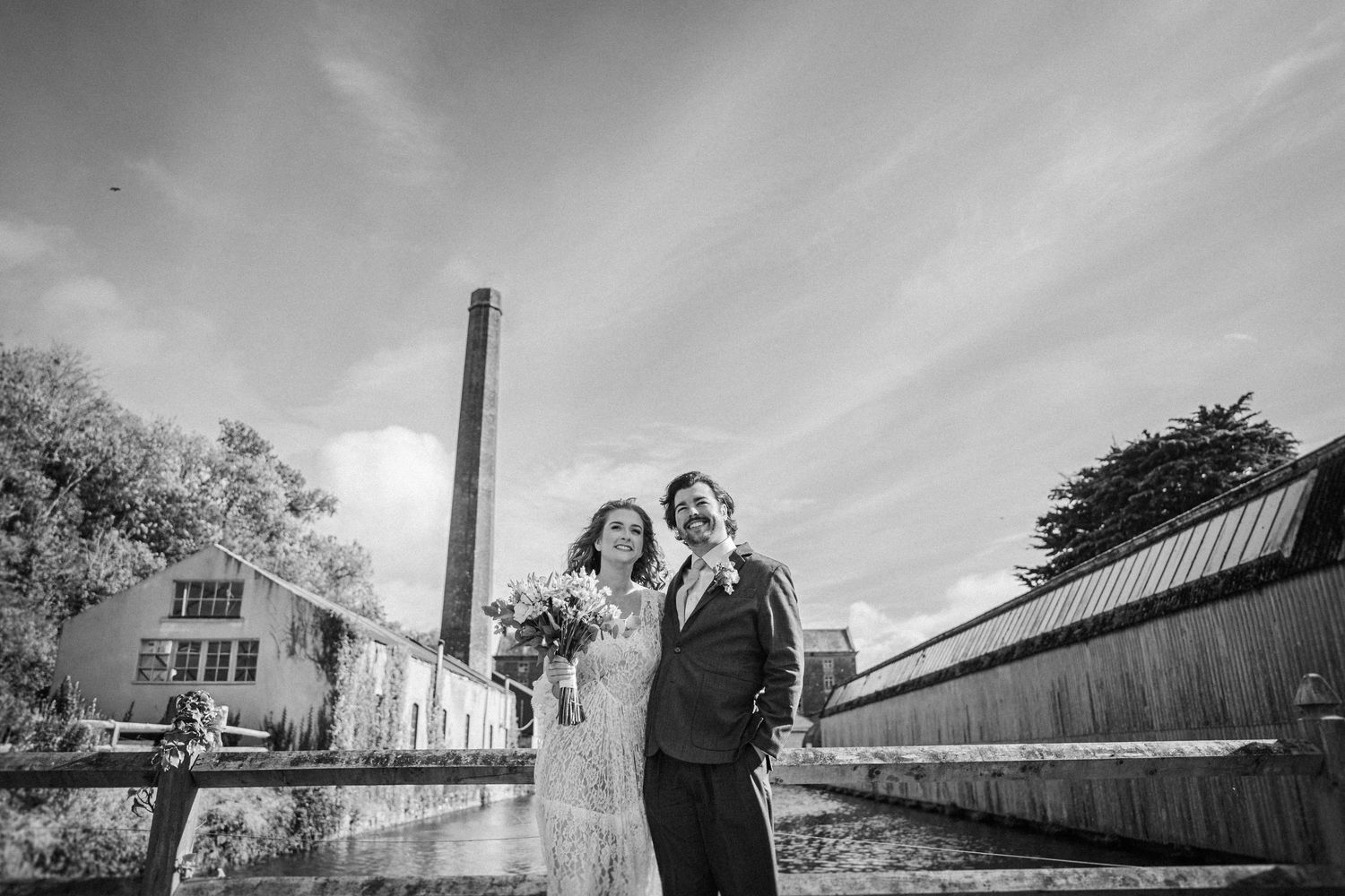 Black and white wedding photos displayed in a horizontal collage showing romantic moments at an industrial venue.