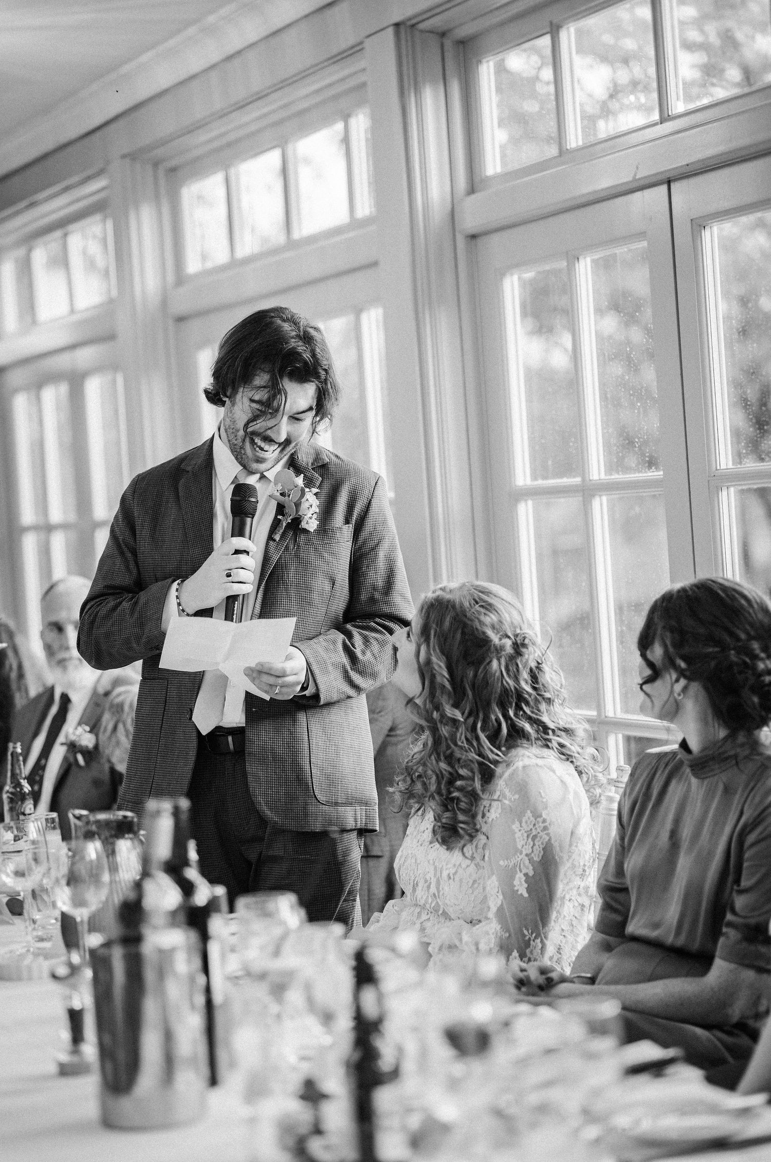 A sequence of black and white photos showing candid moments during a formal dining event with guests interacting.