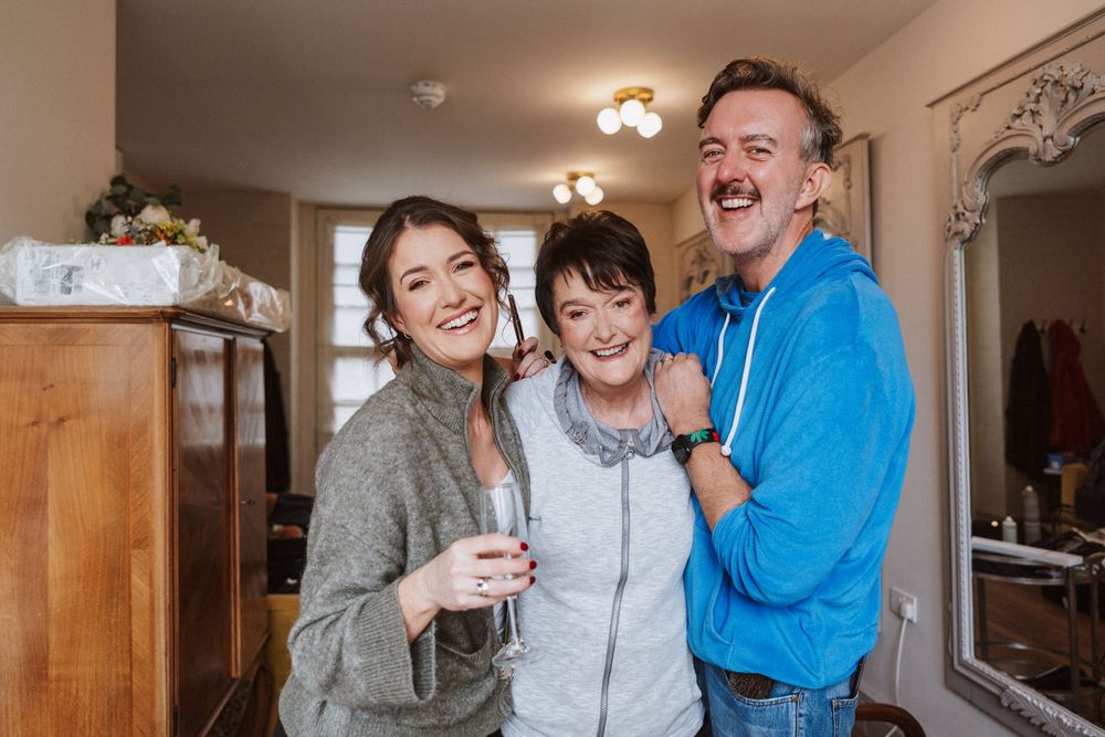 Family members share joyful moments together while laughing and embracing in their bright home interior.