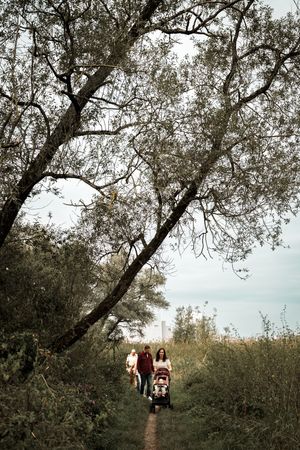 A series of photos showing people walking along a scenic tree-lined path on a cloudy autumn day.