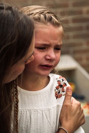 A series of candid emotional moments showing a person in a white knit sweater with a butterfly embellishment.