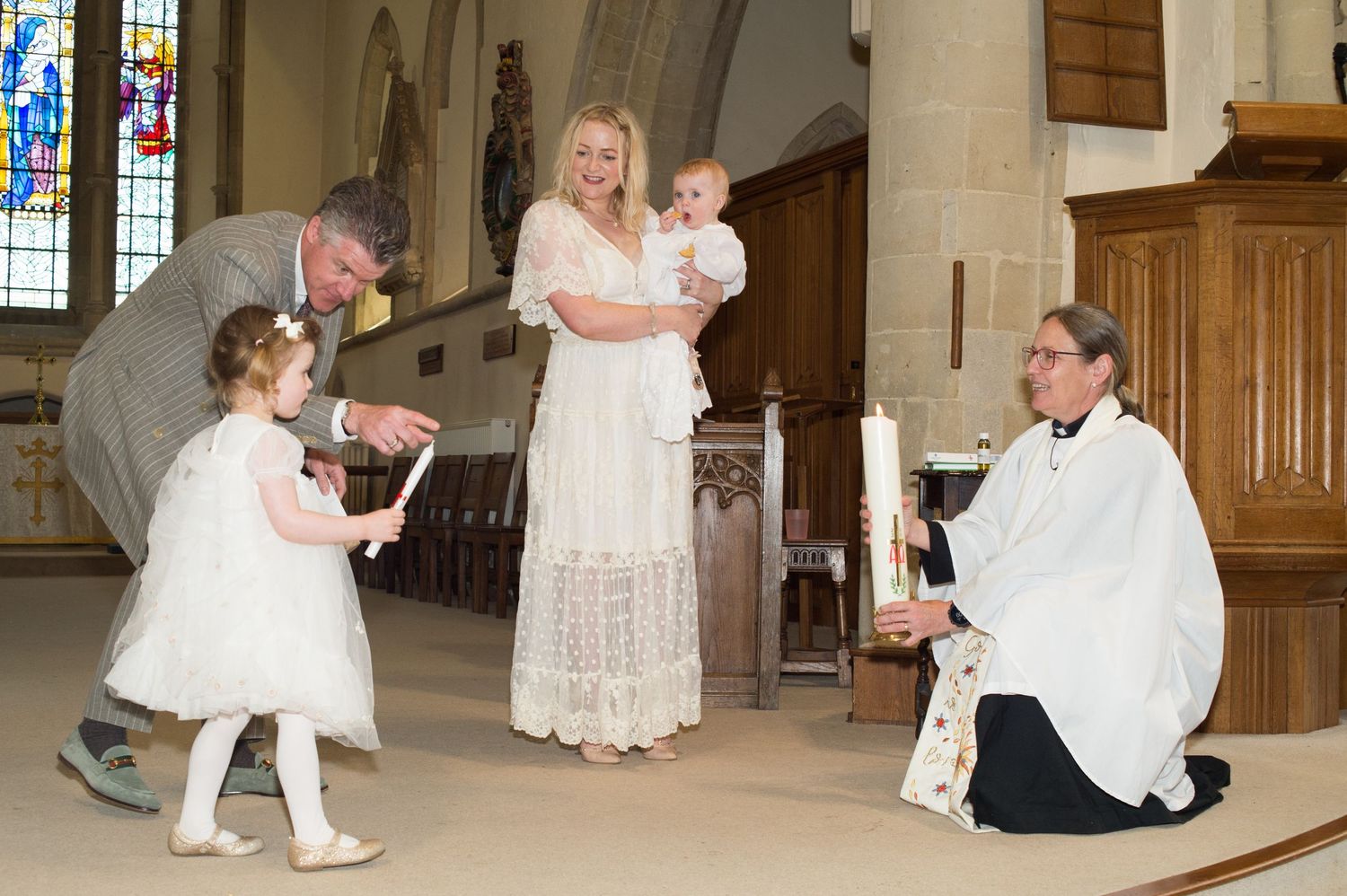 A man and daughter with a candle, captured in a christening photograph at Abigail's Studio, Buckinghamshire.