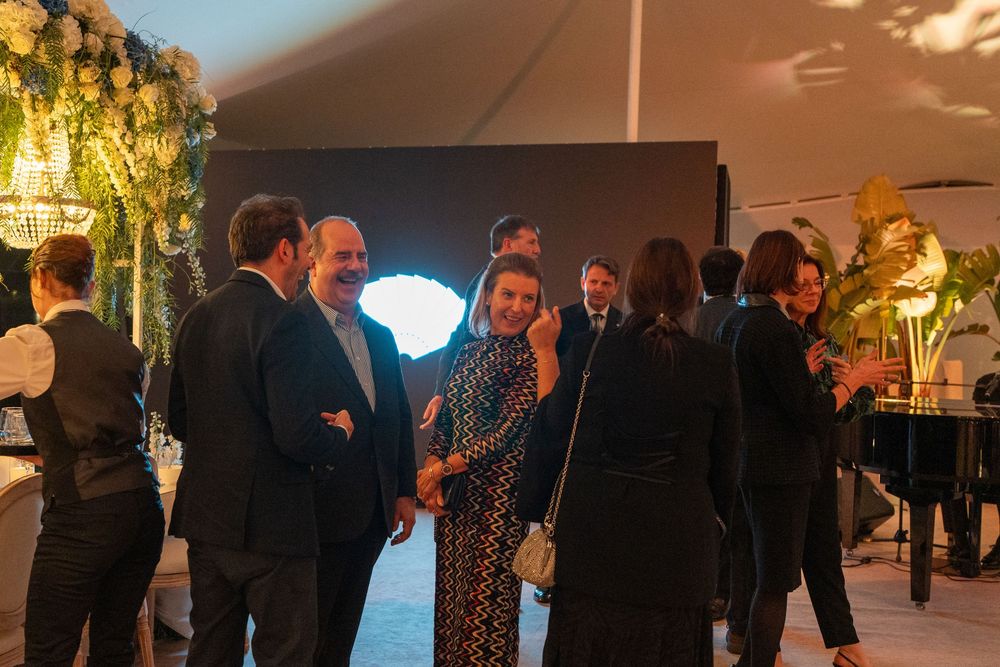 People dancing and socializing at an indoor evening event with warm lighting and decorative elements.