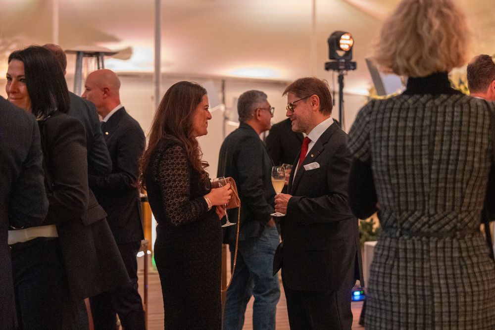 People mingling and socializing at an indoor networking event with warm lighting.