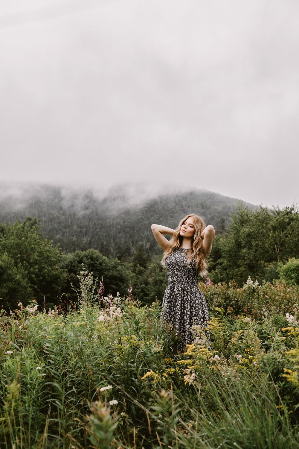 Rachel Delong, Christian musician, poses in a field with a foggy hill in background in the White Mountains of New Hampshire.