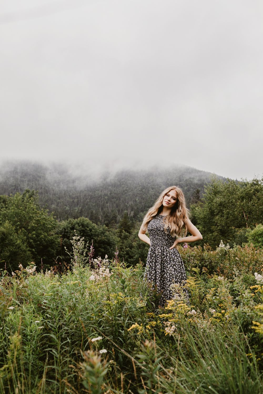 Rachel Delong, Christian musician, poses in a field with a foggy hill in background for a portrait in the White Mountains of New Hampshire.