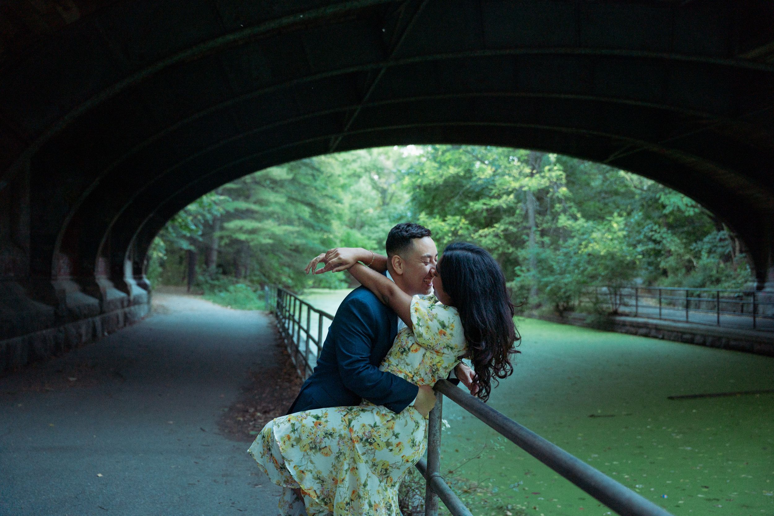 A romantic moment captured under a stone bridge tunnel in Central Park.