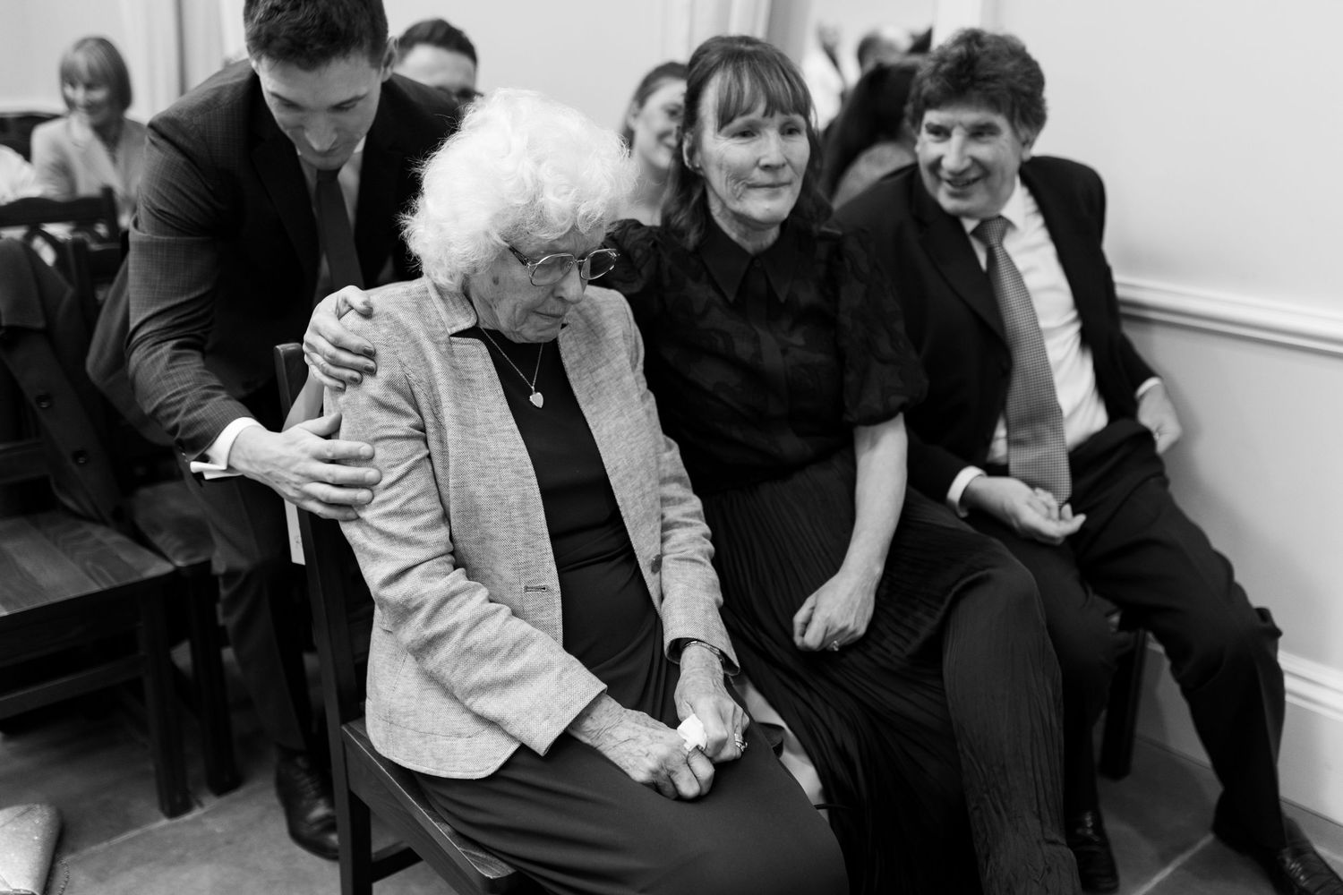A series of black and white candid photographs showing people seated together in casual social settings.