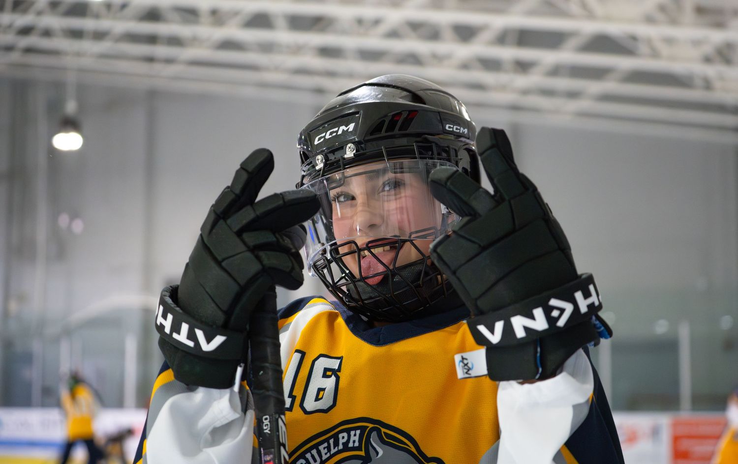 Ringette player in yellow jersey posing for a picture