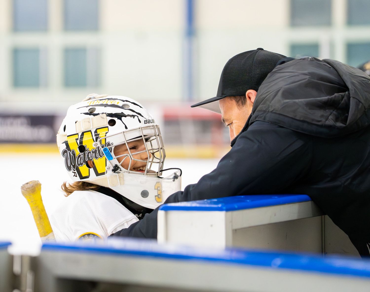 Hockey coach embracing the goalie during a timeout.