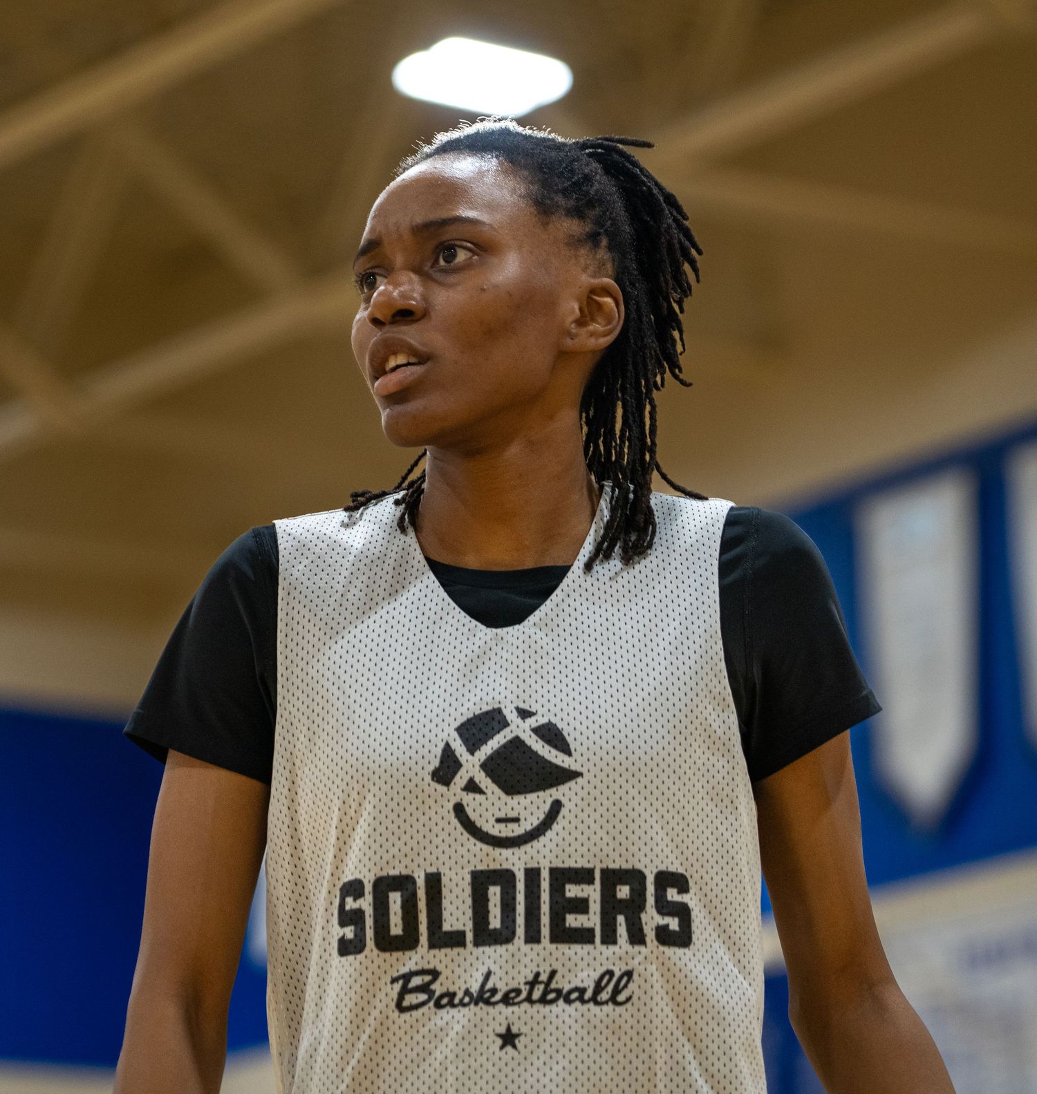 Basketball players in practice jerseys with 'Soldiers' text during a game.
