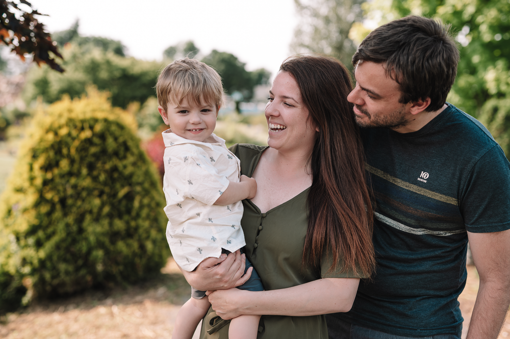 A happy family enjoying time together outdoors in a garden setting during golden hour lighting.