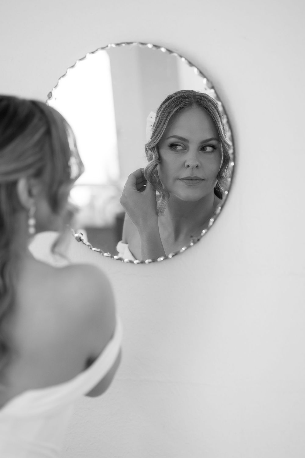 Artistic black and white reflections in decorative mirrors show wedding day preparations.