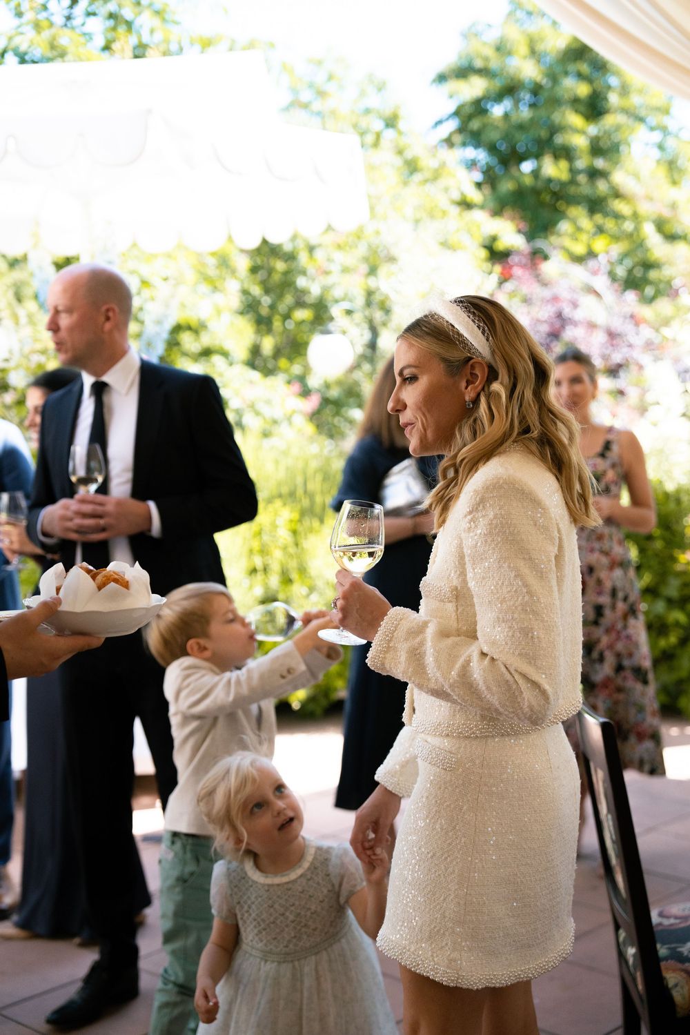 Wedding guests dance together during a joyful celebration on an outdoor patio.