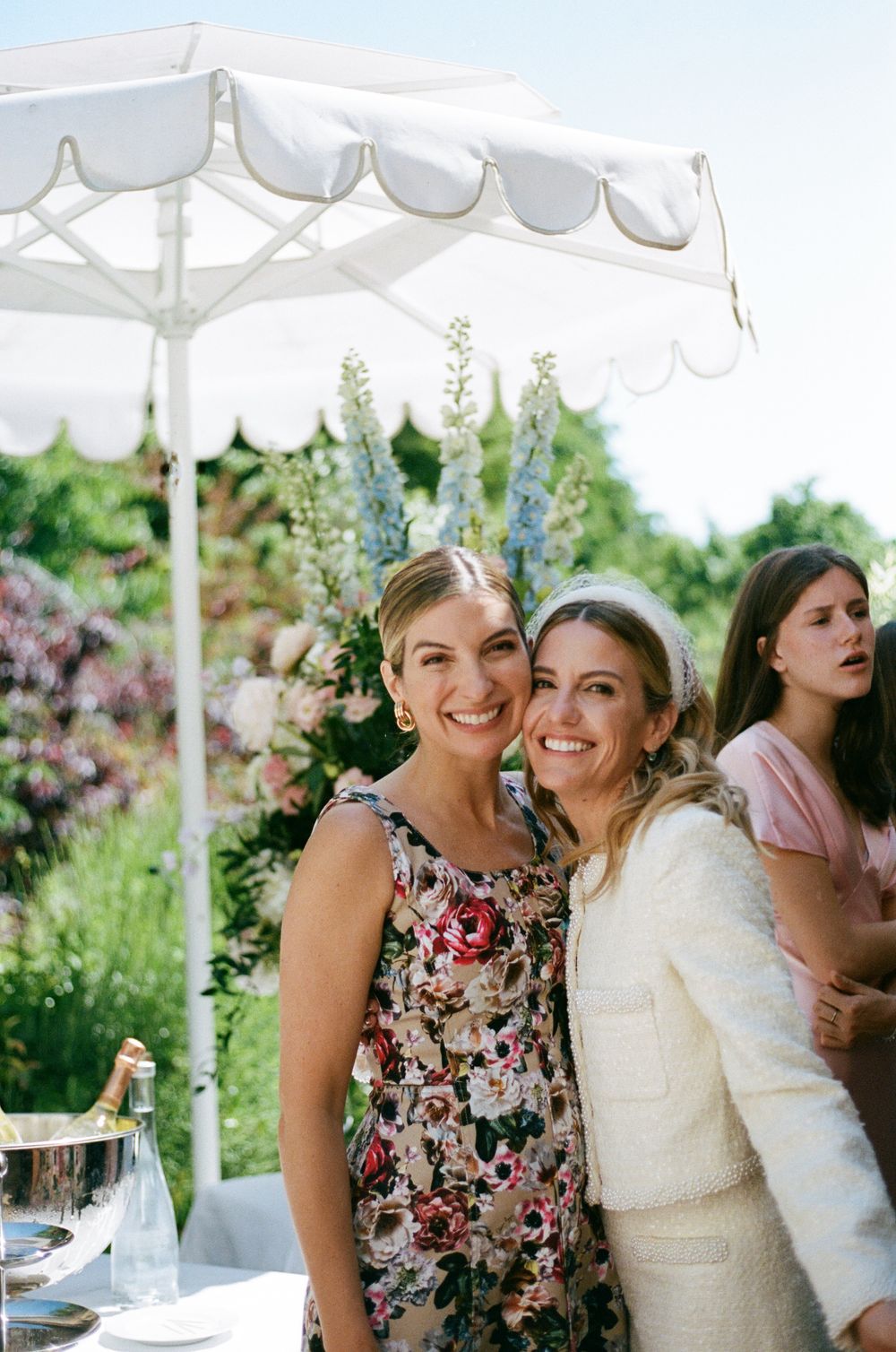 Outdoor garden party under white canopy with floral arrangements and elegant table settings in summer. Film photographer in Paris.