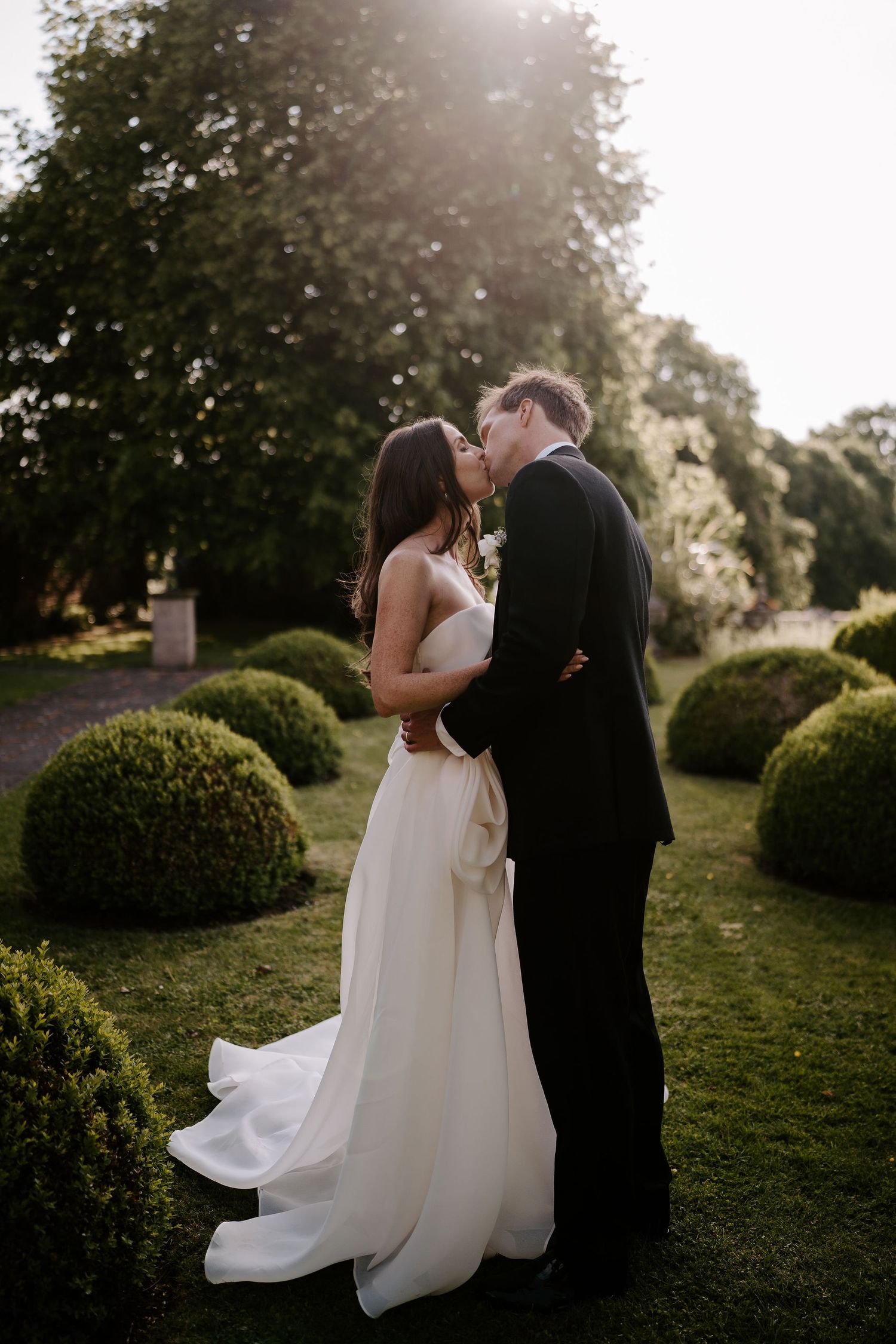 bride and groom kissing on the lawn at dewsall court in herefordshire