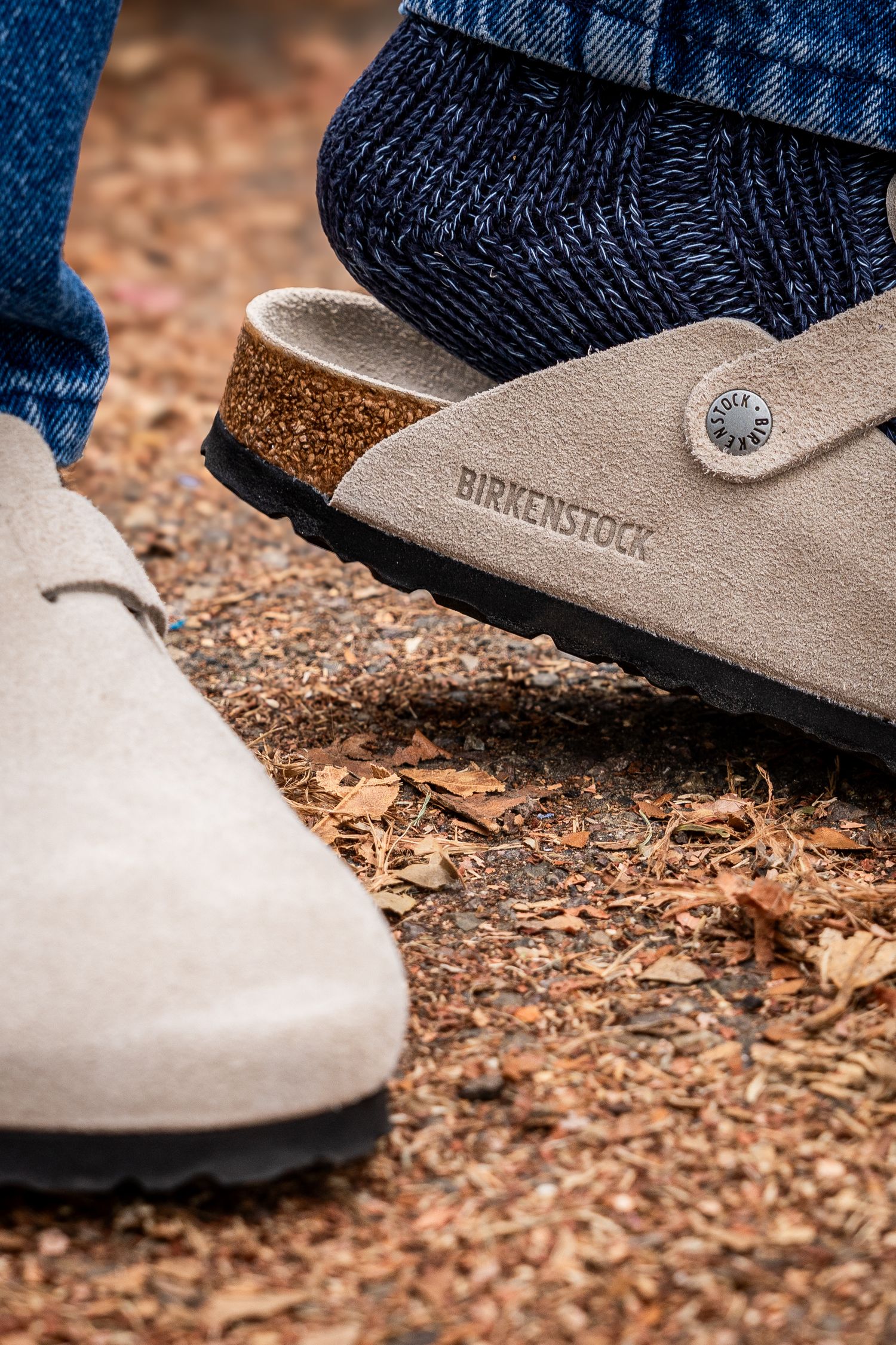 Close up of Birkenstock sandals in a tan color standing on crumbled leaves