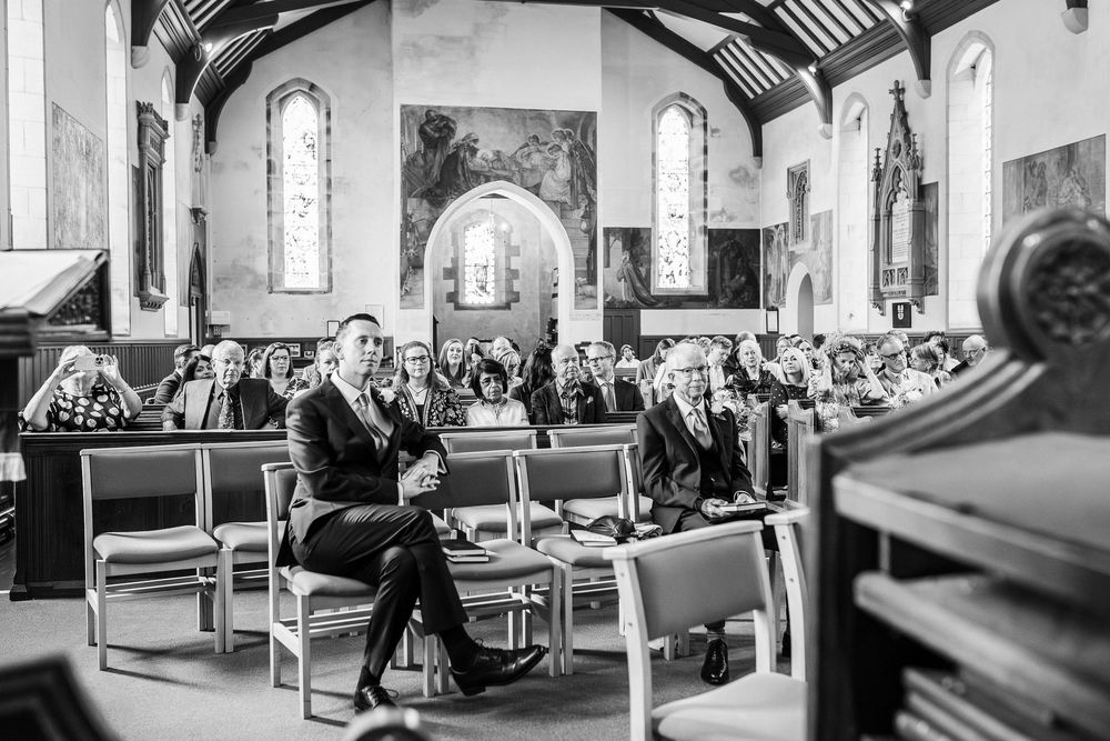 Black and white photograph of a church congregation seated in wooden pews during a service.