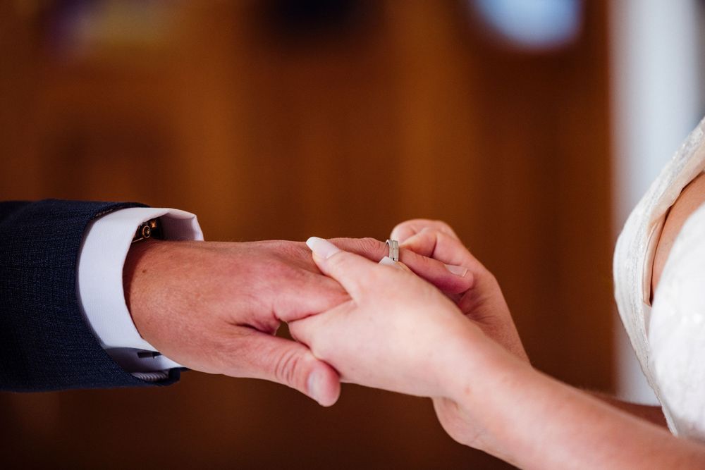 Two hands exchanging a white business card or payment card in a professional setting.