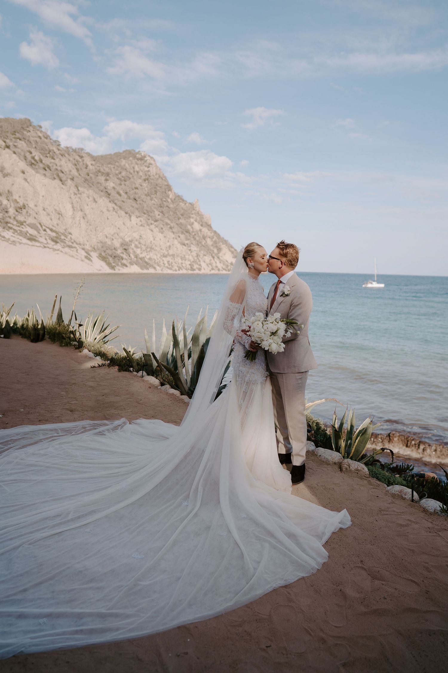 bride and groom kissing with sea in the background at amante ibiza
