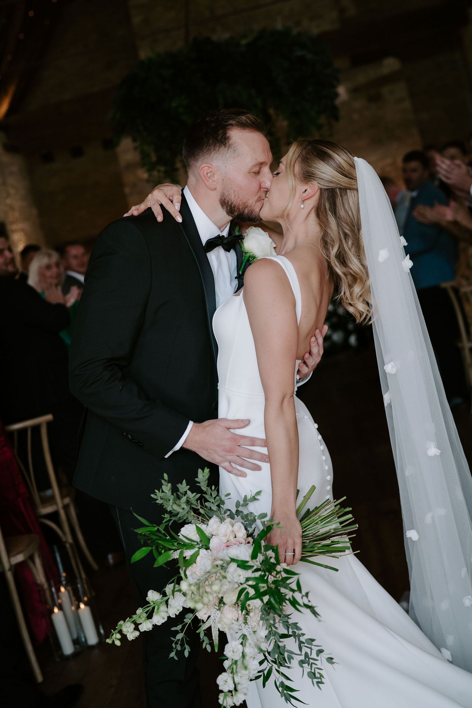 bride and groom kissing at end of the ceremony aisle at ivy lodge in cirencester