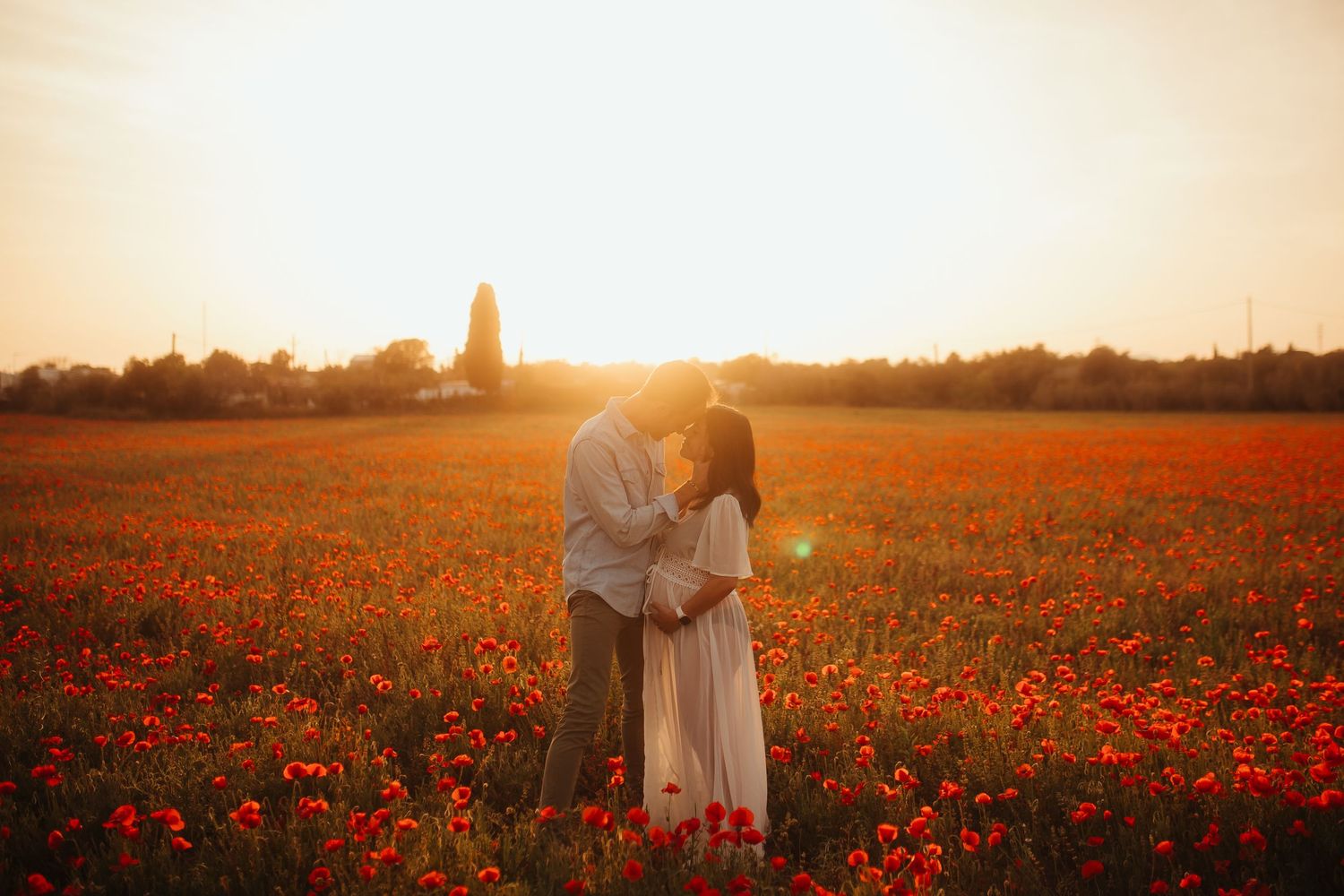 Pareja embarazada en un campo de amapolas al atardecer en Tarragona