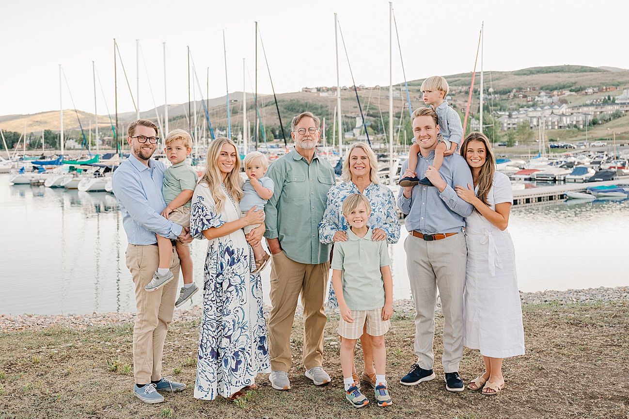 Extended family gathering at a coastal marina with boats and natural scenery.