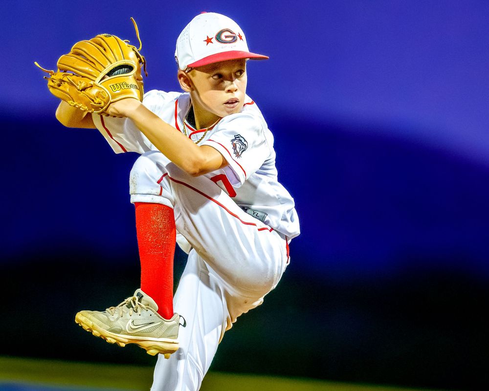 Little league pitcher winding up to throw, action shot on the mound, SportsFox Photography.
