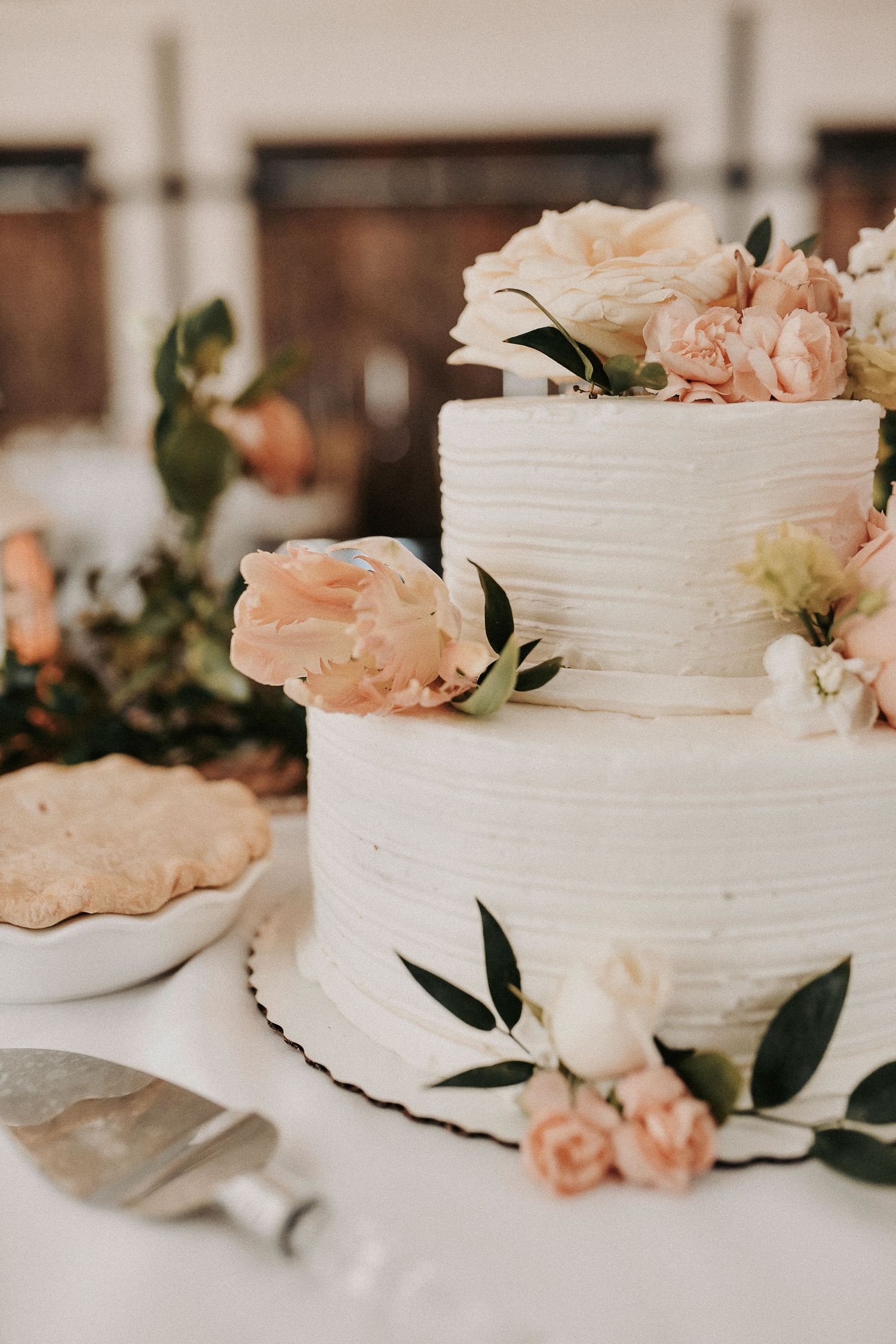 Spring wedding reception cake showcasing place settings, florals, and romantic details.