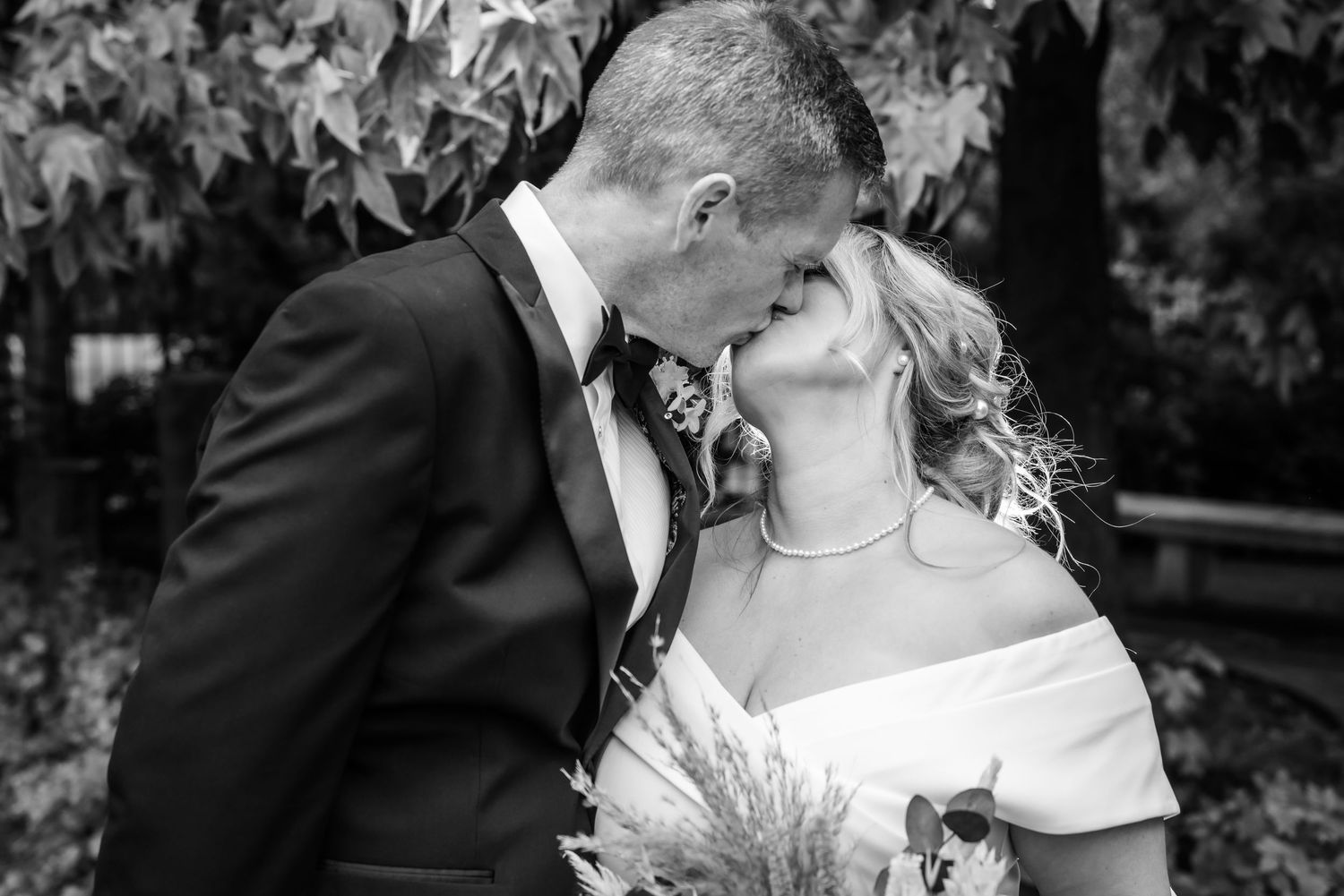 Black and white wedding photo showing intimate moment between newlyweds with bride holding rustic bouquet at Runcorn Town Hall
