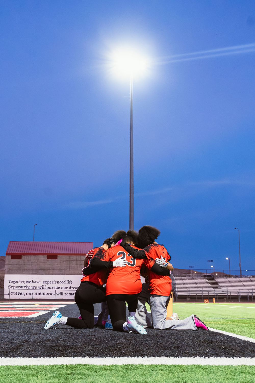 Girls flag football players having a prayer before a game