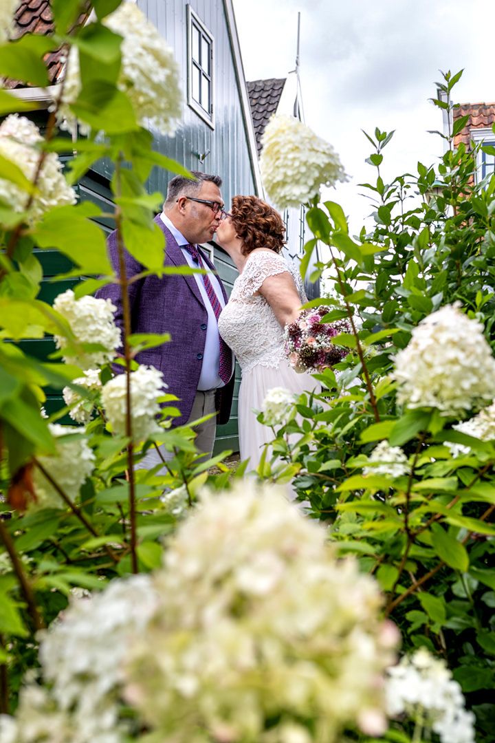 Bruidspaar kust elkaar tijdens de fotoshoot Lisse de Zaanse huisjes in Zaandijk