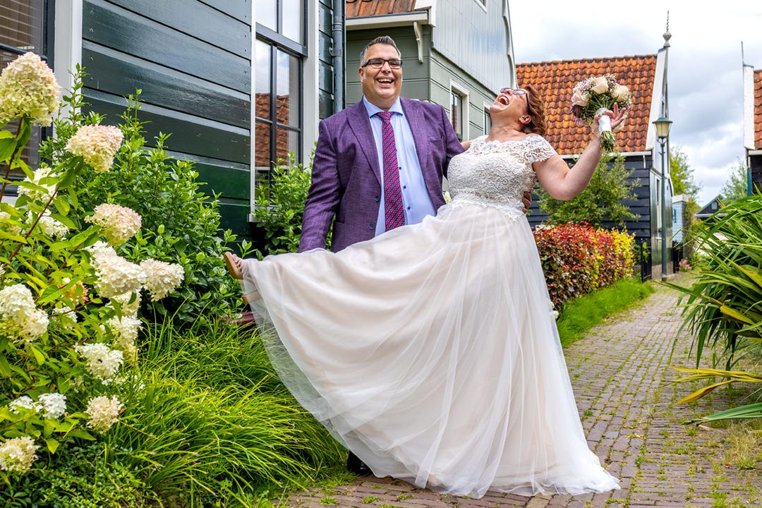 Robin en Kirsten lachen samen tijdens hun fotoshoot tussen de Zaanse huisjes in Zaandijk