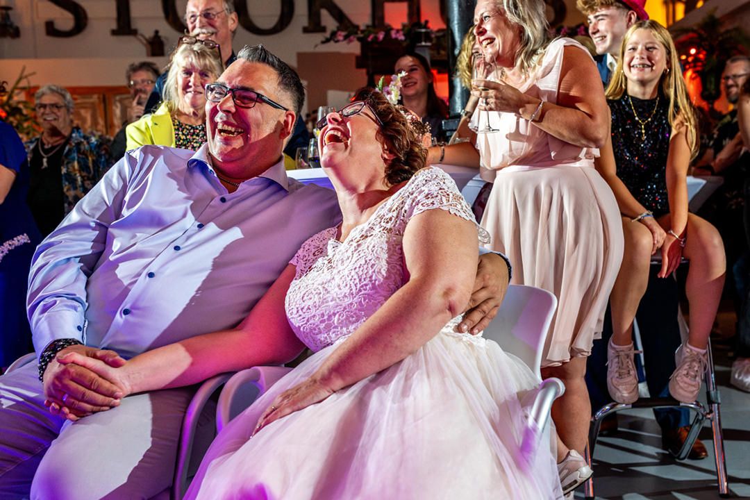 Bruidspaar moet ontzettend lachen om de speech die gegeven wordt tijdens het trouwfeest