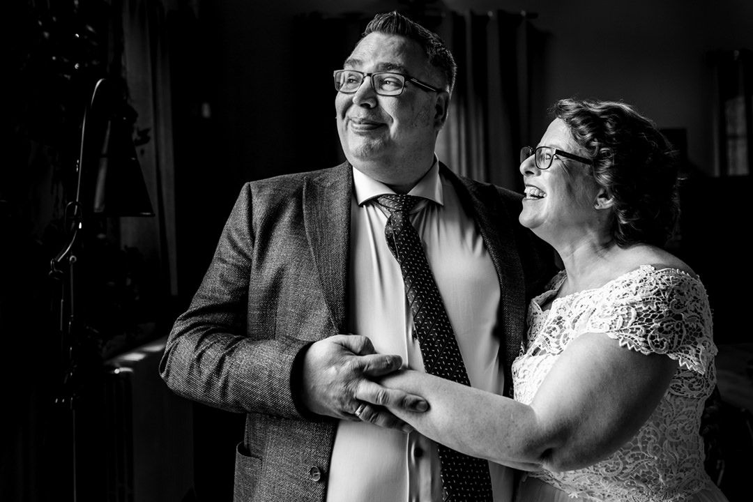 Zwart-wit foto van het bruidspaar dat elkaar vasthoudt en geniet van een rustig moment