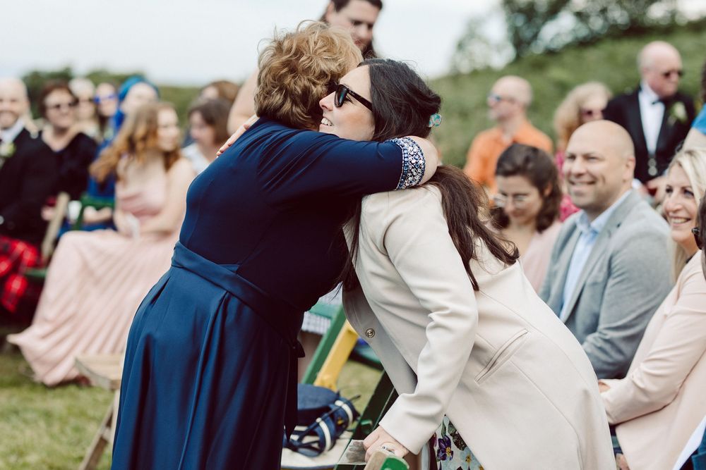 A couple shares an intimate moment during their outdoor wedding ceremony while guests look on with joy.