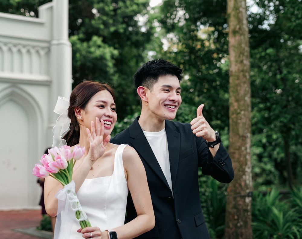 Happy couple celebrating their wedding day with flowers in an outdoor setting.