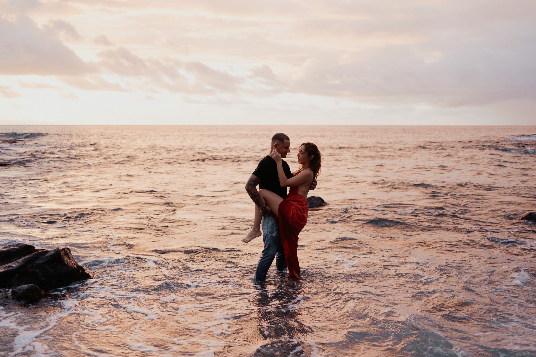 une pose glamour de deux fiancés dans la mer