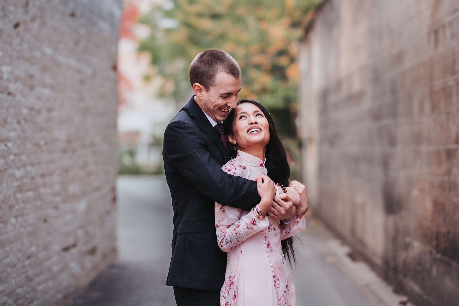 Romantic couple sharing a tender moment in an urban alley during portrait session.